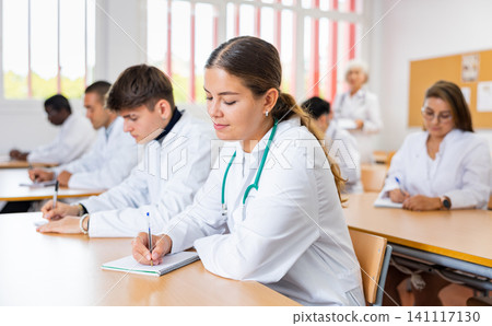 Young woman medical student attending lecture in university Young woman medical student attending lecture in university 141117130