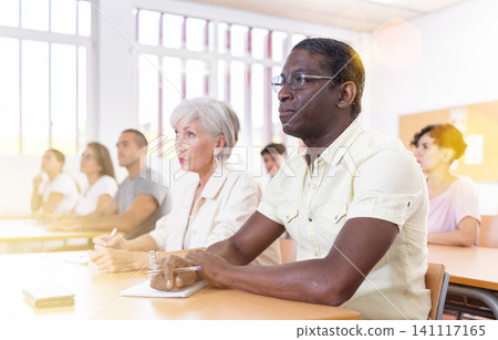 Man attending foreign language course in classroom Man attending foreign language course in classroom 141117165