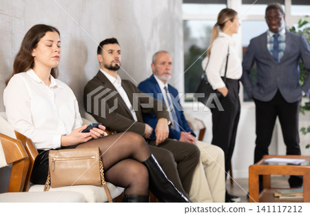 Applicants are waiting for interview, there is queue of people sitting in waiting room. Applicants are waiting for interview, there is queue of people sitting in waiting room. 141117212
