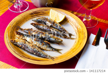 Deliciously fried many sardines served with lemon at plate Deliciously fried many sardines served with lemon at plate 141117214