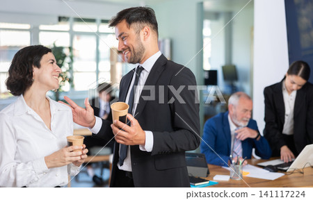 Man and a woman with hot drinks at work Man and a woman with hot drinks at work 141117224