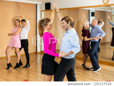 Happy couple performing a paired dance in ballroom 141117318