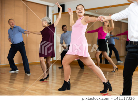 Cheerful female dancer practicing ballroom dances in ballroom Cheerful female dancer practicing ballroom dances in ballroom 141117326