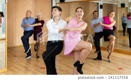 Young pair practicing Latino dance in dance studio Young pair practicing Latino dance in dance studio 141117358