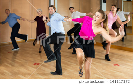 Woman with partner enjoying upbeat jive in dance studio Woman with partner enjoying upbeat jive in dance studio 141117372