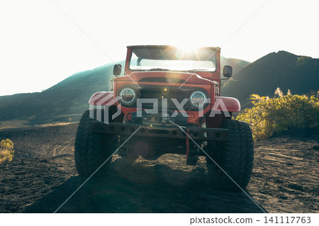 Vintage off-road vehicle parked on volcanic terrain at sunset Vintage off-road vehicle parked on volcanic terrain at sunset 141117763