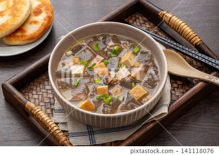 traditional Chinese sweet potato starch jelly soup with tofu cubes and green onions in a ceramic bowl traditional Chinese sweet potato starch jelly soup with tofu cubes and green onions in a ceramic bowl 141118076