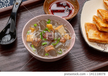 traditional Chinese sweet potato starch jelly soup with tofu cubes and green onions in a ceramic bowl traditional Chinese sweet potato starch jelly soup with tofu cubes and green onions in a ceramic bowl 141118078