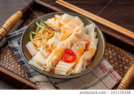 shaanxi style flavored Liangpi cold noodles with peanut sauce, cucumber, and onion on a wooden tray shaanxi style flavored Liangpi cold noodles with peanut sauce, cucumber, and onion on a wooden tray 141118186