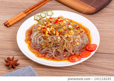 spicy cold glass noodle salad with chopped chili, garlic, and cherry tomatoes on a white plate spicy cold glass noodle salad with chopped chili, garlic, and cherry tomatoes on a white plate 141118285