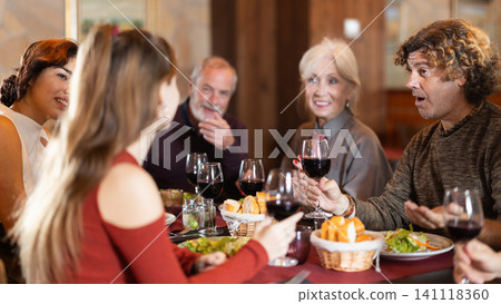 Family members enjoying warm conversation in restaurant Family members enjoying warm conversation in restaurant 141118360