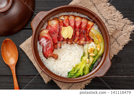 Traditional Cantonese claypot rice with cured pork belly bacon on bamboo mat, Chinese baozaifan Traditional Cantonese claypot rice with cured pork belly bacon on bamboo mat, Chinese baozaifan 141118479