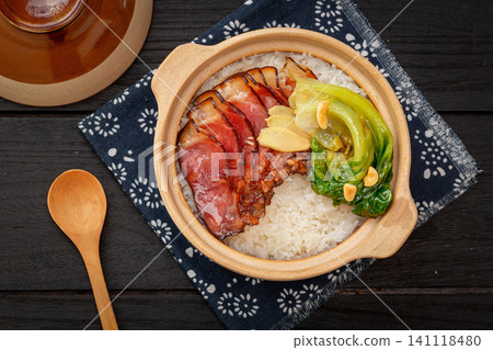Traditional Cantonese claypot rice with cured pork belly bacon on bamboo mat, Chinese baozaifan Traditional Cantonese claypot rice with cured pork belly bacon on bamboo mat, Chinese baozaifan 141118480