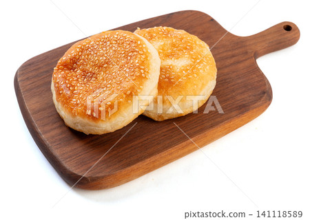 Traditional Chinese Tianjin style flaky pastry shaobing topped with white sesame seeds, isolated Traditional Chinese Tianjin style flaky pastry shaobing topped with white sesame seeds, isolated 141118589