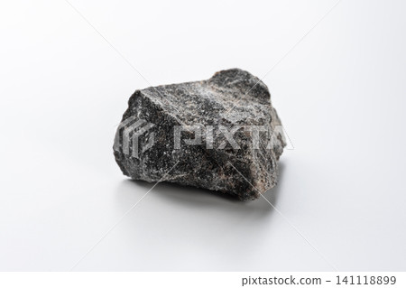 A chunk of black Himalayan rock salt placed against a white background. A chunk of black Himalayan rock salt placed against a white background. 141118899