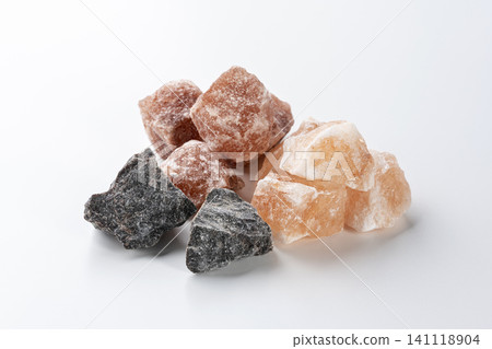 Pink, orange, and black Himalayan rock salt lined up against a white background. Pink, orange, and black Himalayan rock salt lined up against a white background. 141118904