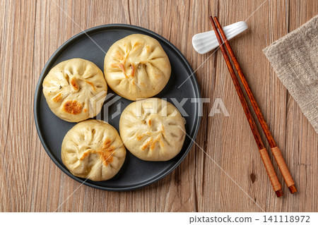 Chinese Pan Fried Stuffed Buns on Wooden Table Traditional Breakfast Snack 141118972