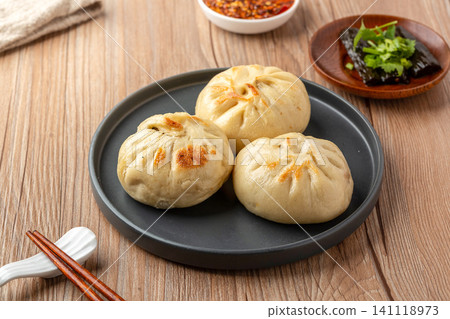 Chinese Pan Fried Stuffed Buns on Wooden Table Traditional Breakfast Snack Chinese Pan Fried Stuffed Buns on Wooden Table Traditional Breakfast Snack 141118973