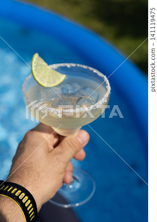 Enjoying a refreshing margarita by the pool on a sunny day Enjoying a refreshing margarita by the pool on a sunny day 141119475