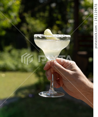 Enjoying a refreshing margarita in the garden on a sunny weekend Enjoying a refreshing margarita in the garden on a sunny weekend 141119478