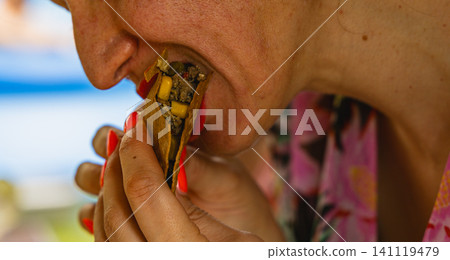 Eating a taco at a street stall in Mexico during a sunny day Eating a taco at a street stall in Mexico during a sunny day 141119479