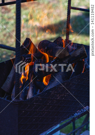 Warm fire in grill with flames and smoke ready for outdoor cooking Warm fire in grill with flames and smoke ready for outdoor cooking 141119482