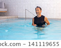 A smiling senior man doing water walking in a swimming pool. 141119655