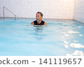 A smiling senior man doing water walking in a swimming pool. 141119657
