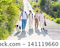 A two-generation family enjoying a walk with their beloved dog. 141119660