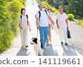 A two-generation family enjoying a walk with their beloved dog. 141119661