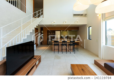 A modern living and dining room with a high ceiling. A modern living and dining room with a high ceiling. 141119784
