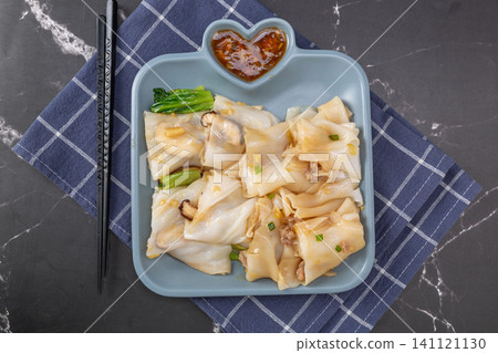 Steamed rice noodle rolls with mushrooms and minced pork on a blue plate Steamed rice noodle rolls with mushrooms and minced pork on a blue plate 141121130