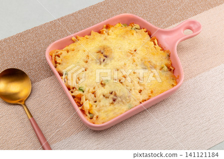 baked rice casserole with sweet corn and melted mozzarella cheese topping in pink baking dish. baked rice casserole with sweet corn and melted mozzarella cheese topping in pink baking dish. 141121184