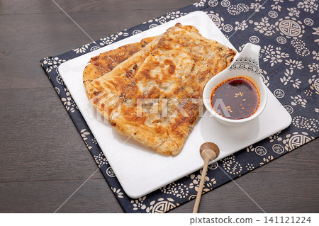 crispy Chinese flatbread stuffed with savory preserved mustard greens, traditional baked pancake. crispy Chinese flatbread stuffed with savory preserved mustard greens, traditional baked pancake. 141121224