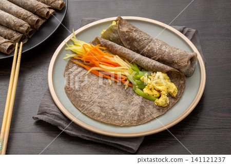 chinese healthy buckwheat wraps stuffed with shredded potato and carrots on plate chinese healthy buckwheat wraps stuffed with shredded potato and carrots on plate 141121237