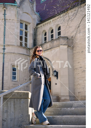 Woman in Grey Coat Posing on Historic Stone Staircase Woman in Grey Coat Posing on Historic Stone Staircase 141121492