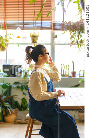 A woman wearing glasses resting by the window. A woman wearing glasses resting by the window. 141121603