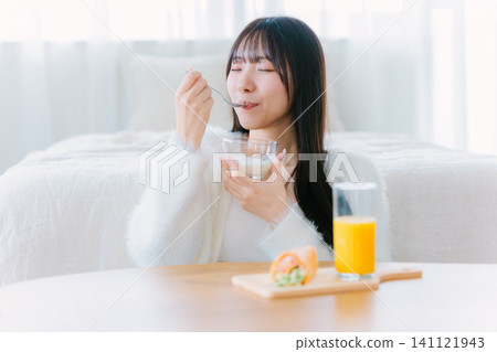 一位年輕女子在家吃早餐 141121943