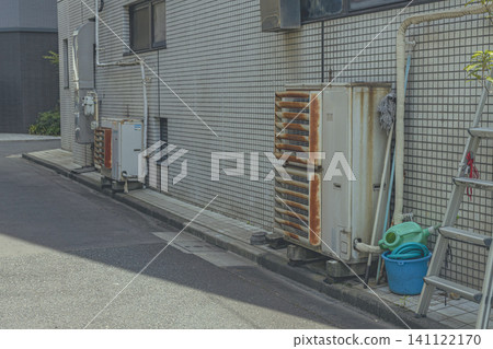 Rusty outdoor air conditioning units lined up in the back alley Rusty outdoor air conditioning units lined up in the back alley 141122170
