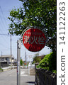 在寧靜的住宅區街道上，矗立著一個紅色的圓形消防栓標誌。 141122263