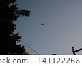 一架小型飛機在昏暗的暮色中高高飛翔。 141122268