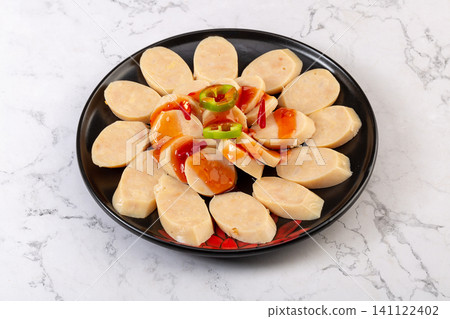 sliced garlic pork sausage salad with sauce and green pepper garnish sliced garlic pork sausage salad with sauce and green pepper garnish 141122402
