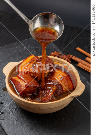 chinese Braised Pork Belly with Rich Soy Gravy Poured from Ladle in Clay Pot chinese Braised Pork Belly with Rich Soy Gravy Poured from Ladle in Clay Pot 141122466