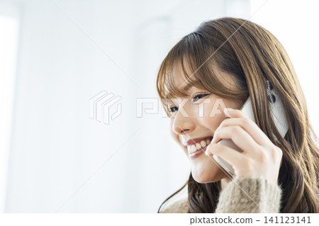 Young woman talking on a smartphone Young woman talking on a smartphone 141123141