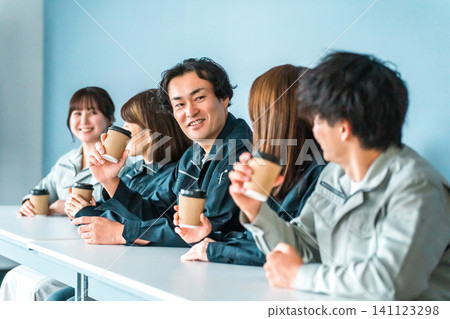 穿著工作服的女人和男人在辦公室休息區喝咖啡 穿著工作服的女人和男人在辦公室休息區喝咖啡 141123298