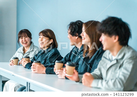 穿著工作服的女人和男人在辦公室休息區喝咖啡 穿著工作服的女人和男人在辦公室休息區喝咖啡 141123299