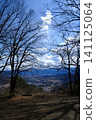The blue sky visible through the old stone buildings and bare tree branches. 141125064