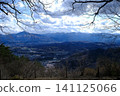 A view from a viewpoint overlooking the mountains: bare trees and cloudy sky. 141125066