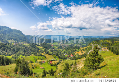 Amazing alpine landscape with green fields and Piatra Craiului mountains in Dambovicioara Commune. Amazing alpine landscape with green fields and Piatra Craiului mountains in Dambovicioara Commune. 141125654