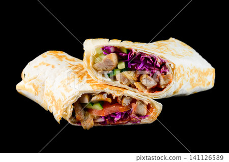 Fresh chicken shawarma wrap cut in half with red cabbage and cucumber on black background side view with copy space delicious savory meat snack Fresh chicken shawarma wrap cut in half with red cabbage and cucumber on black background side view with copy space delicious savory meat snack 141126589